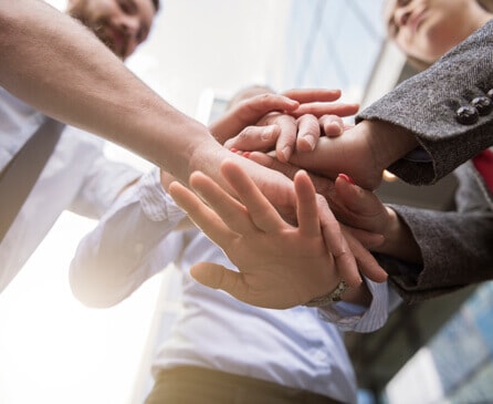 Team putting hands in together